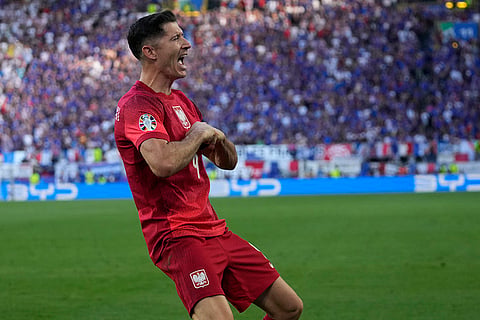 Robert Lewandowski celebrates after scoring a goal against France